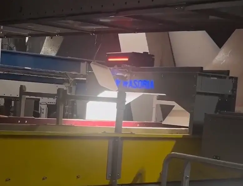 Photographie d'un opérateur regardant un tableau de bord de surveillance des objets dangereux dans un centre de tri